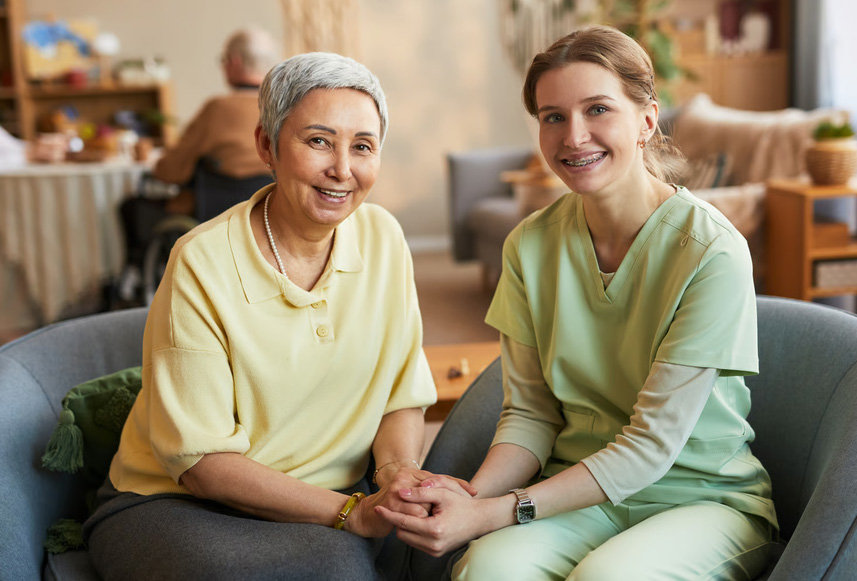 Compassionate hospice caregiver holding hands with an elderly woman, representing support for patients returning to hospice care.